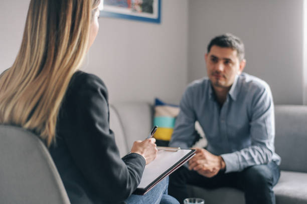 Young man, alcoholic, on  therapy session Young man, alcoholic, talking to female therapist about his problems, on  therapy session substance abuse stock pictures, royalty-free photos & images