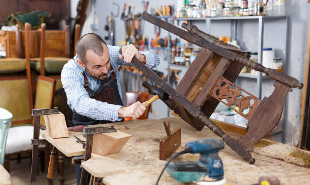 istock Carpenter repairing antique chair 1131102680