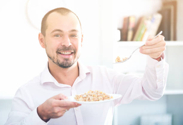 istock Positive young man eating porridge 1131105016