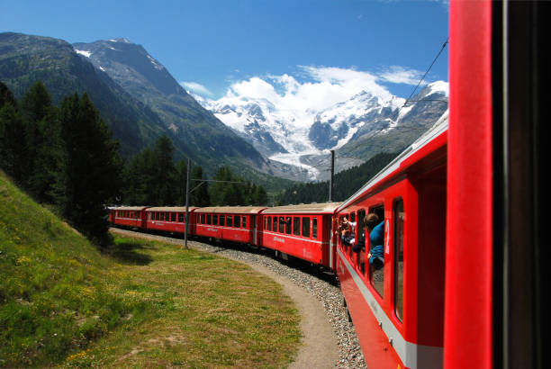 The Bernina Express train of the Rhaetian Railway, with the Morteratsch glacier in the background, Switzerland. stock photo