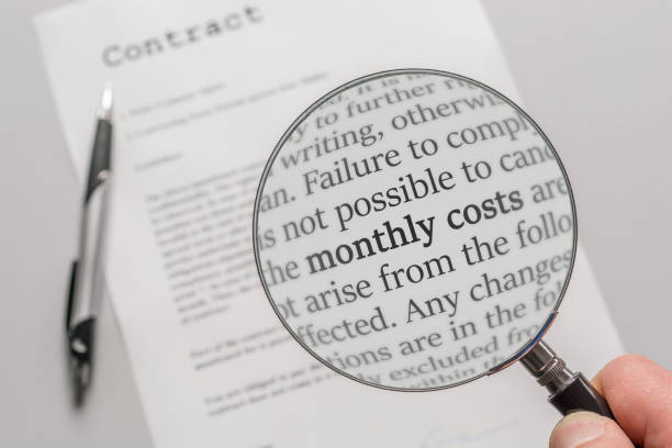 umowa jest sprawdzana za pomocą lupy na temat kosztów miesięcznych w wyniku umowy - condition text magnifying glass contract zdjęcia i obrazy z banku zdjęć
