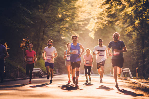 自然の中でマラソンを実行している幸せなアスレチックの人々のグループ。 - marathon running group of people jogging ストックフォトと画像