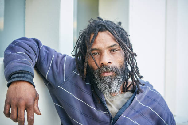 istock Homeless man looking hopeless as he leans on wall 1131113599