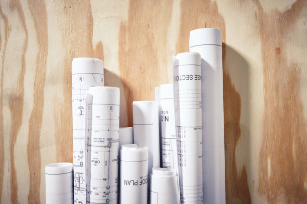 istock Overhead view of rolled-up building plans on desk 1131114049