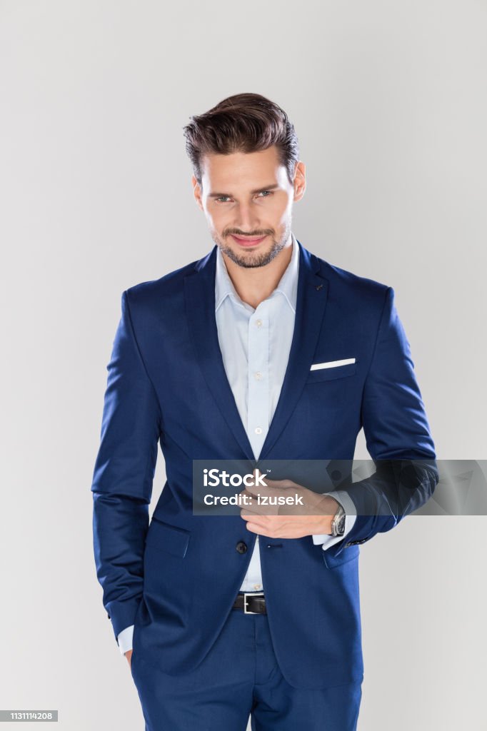 Stylish business man on gray background Portrait of stylish young caucasian business man standing on gray background Suit Stock Photo