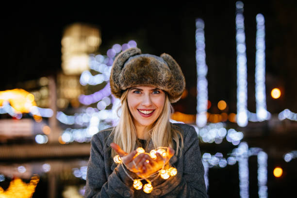 istock Young woman holding Christmas lights 1131114337