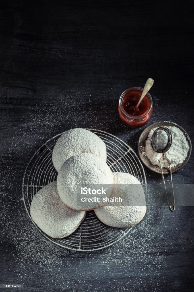 Yummy and fresh donuts on cooling grate on dark table Baked Stock Photo