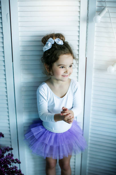 彼女のバレエのスリッパを結ぶ、チュチュでバレリーナとして服を着て愛らしい少女。 - ballet dress studio shot costume ストックフォトと画像