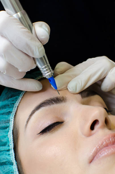 istock Cosmetologist making permanent make up on eyebrows tattoo procedure  in beauty salon, 1131120031