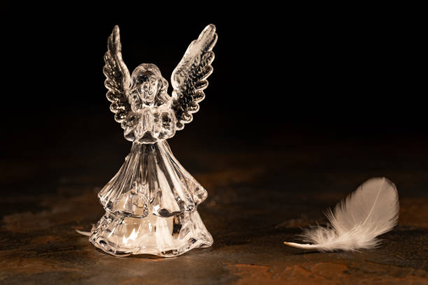 istock Glass angel with fallen feathers on a dark background 1131122885