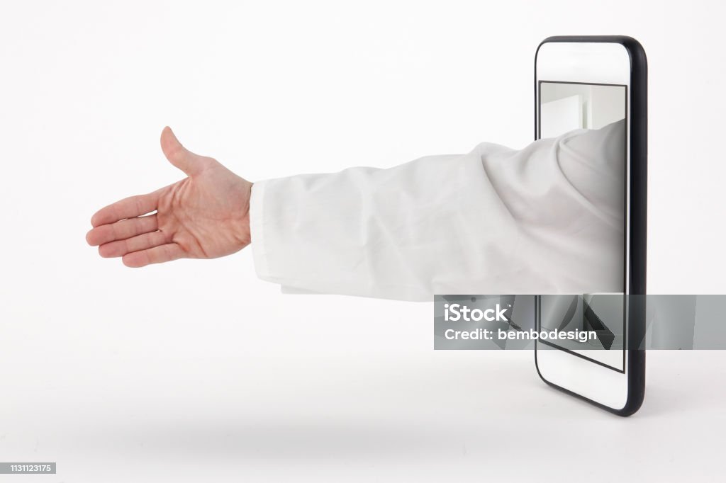 Stretta di mano del dottore con il braccio che esce dal telefono - Foto stock royalty-free di Monitor