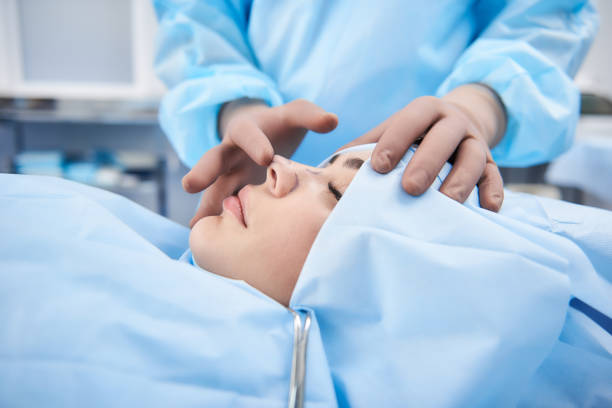 young beautiful woman lying on operating table - nose job imagens e fotografias de stock