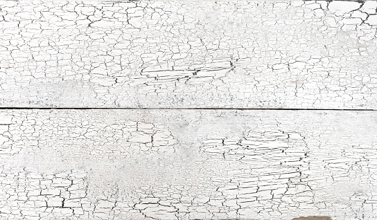 Cracked old white paint on wooden planks, grunge weathered board  surface texture close up top view, vintage pattern worn wood material table, rural grungy rough peeled rustic fence backdrop