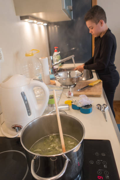 istock Teenage Boy Cooking Tagliatelle Spinach Green Pasta 1131130356