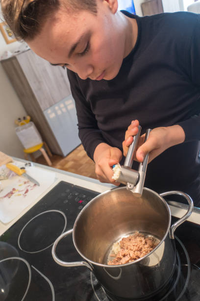 istock Young Boy Preparing Sauce for Pasta 1131130361