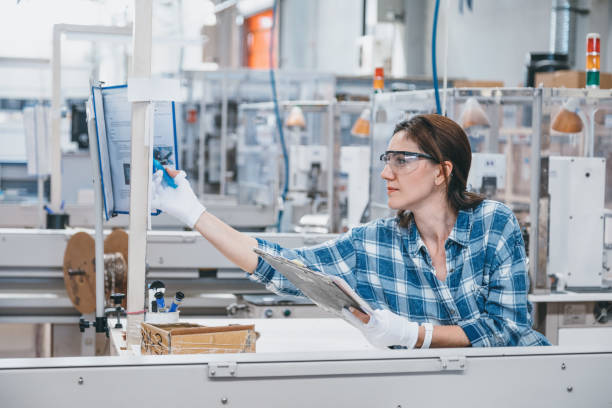 istock Female technician taking notes with manufacturing equipment in a factory 1131131074