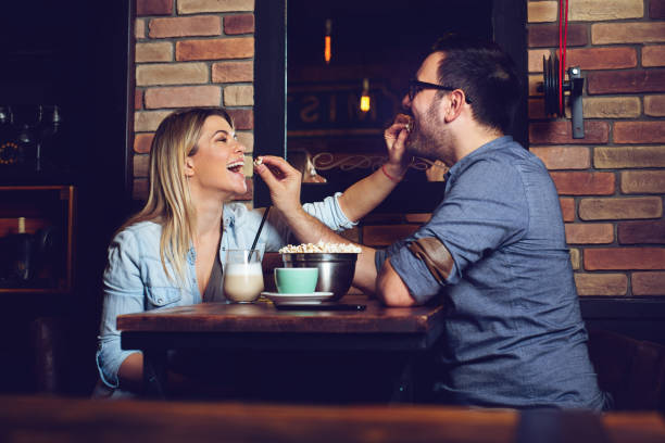 istock Playful couple having fun with peanut during their night out in a pub 1131131259