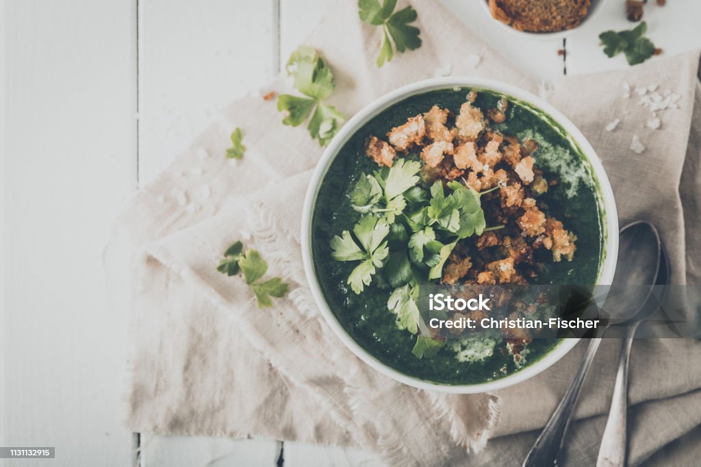 creamy spinach soup with fresh croutons and parsley, top view Bowl Stock Photo