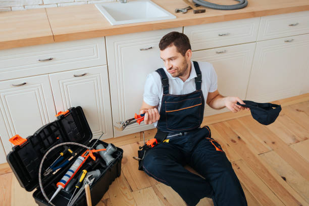 istock Confused young man sit on floor in kitchen and look at toolbox. He hold wrench. Tired man has rest. 1131133079