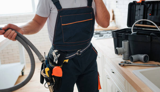 istock Cut view of man standing in kitchen and holding hose. He wear working uniform. Tools on belt. Guy stand at sink. 1131133081