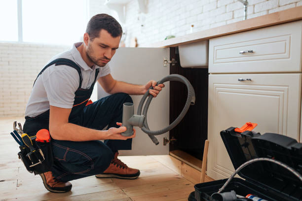 istock Serious concentrated young worker sit in squad pose in kitchen. He hold piece of pipe and hope. Guy doing repair. Opened toolbox on floor. 1131133090