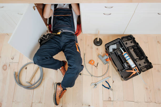 istock Man in uniform work in kitchen under sink. He repair water leaking. Hose and tools on floor. Opened toolbox. 1131133104
