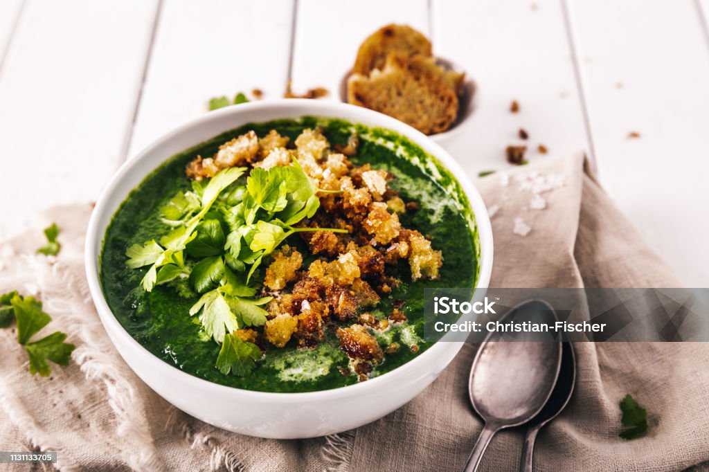 creamy spinach soup with fresh croutons and parsley, top view Bowl Stock Photo