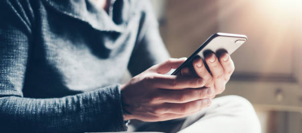 junger mann mit smartphone - telefonnummer wählen stock-fotos und bilder