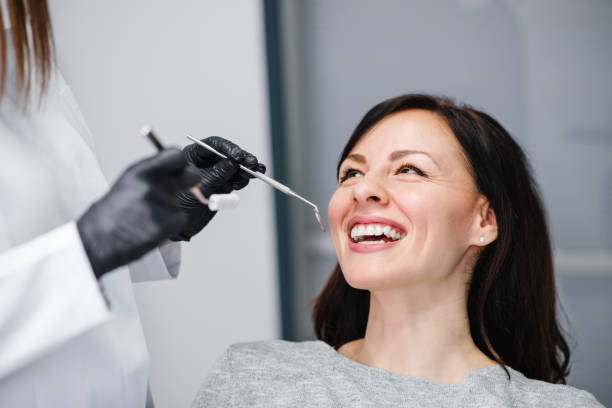 tiro principal da mulher triguenha feliz no escritório do dentista. - smiling dentist office dentists chair women - fotografias e filmes do acervo