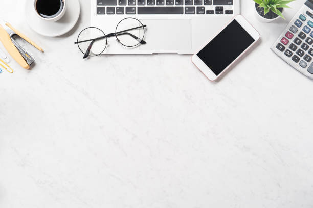 istock Stylized clean marble office working desk with smartphone, laptop, glasses and coffee cup, workspace design, mock up, top view, flat lay, copy space, close up 1131136572
