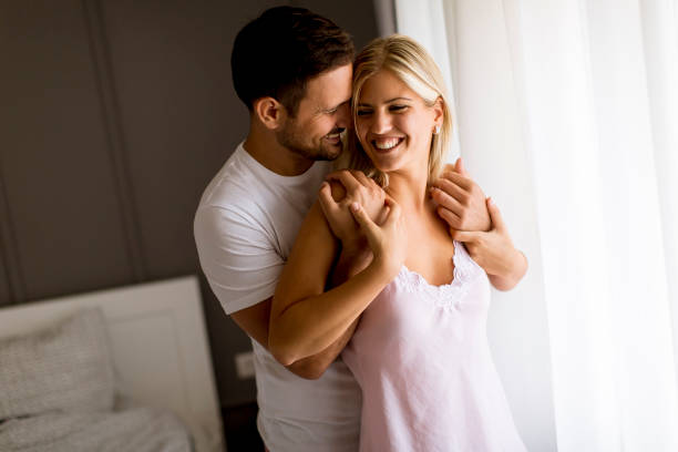 istock Lovely young couple standing by the window 1131140316