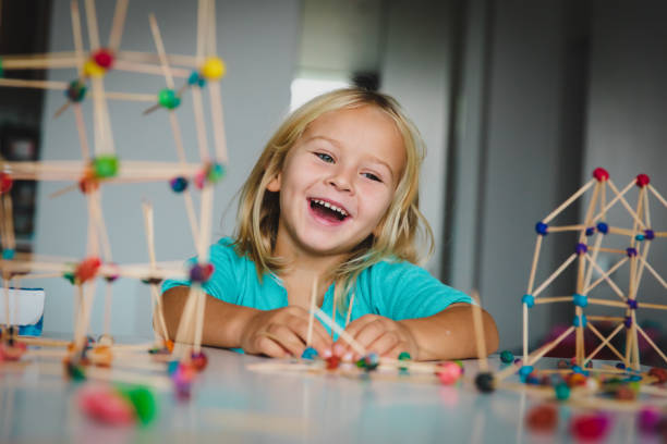 little girl making geometric shapes from sticks and dough, engineering and STEM