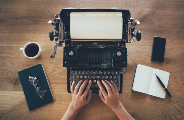 Writer typing on vintage typewriter stock photo