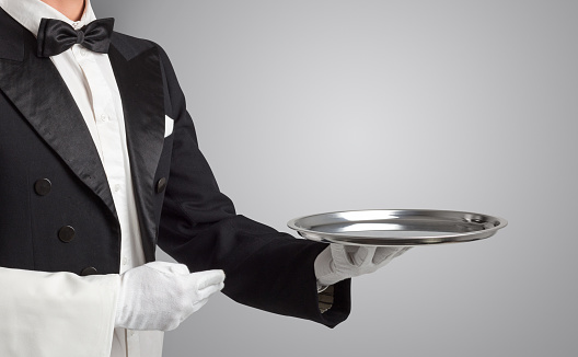 Waiter is carrying plates with delicious meals for the luxury restaurant guests.