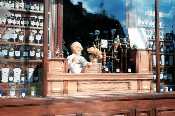 showcase of a vintage pharmacy with potions, flasks, bottles and a puppet pharmacist - old laboratory alchemy alchemist imagens e fotografias de stock