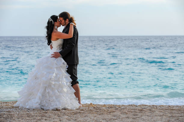 istock Bride and groom walking on the beach 1131144204