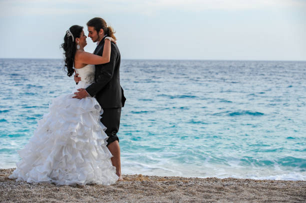 istock Bride and groom walking on the beach 1131144209