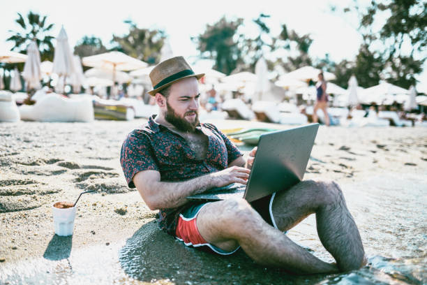istock Hipster Author Is Writing Poetry On Laptop At The Beach 1131144274