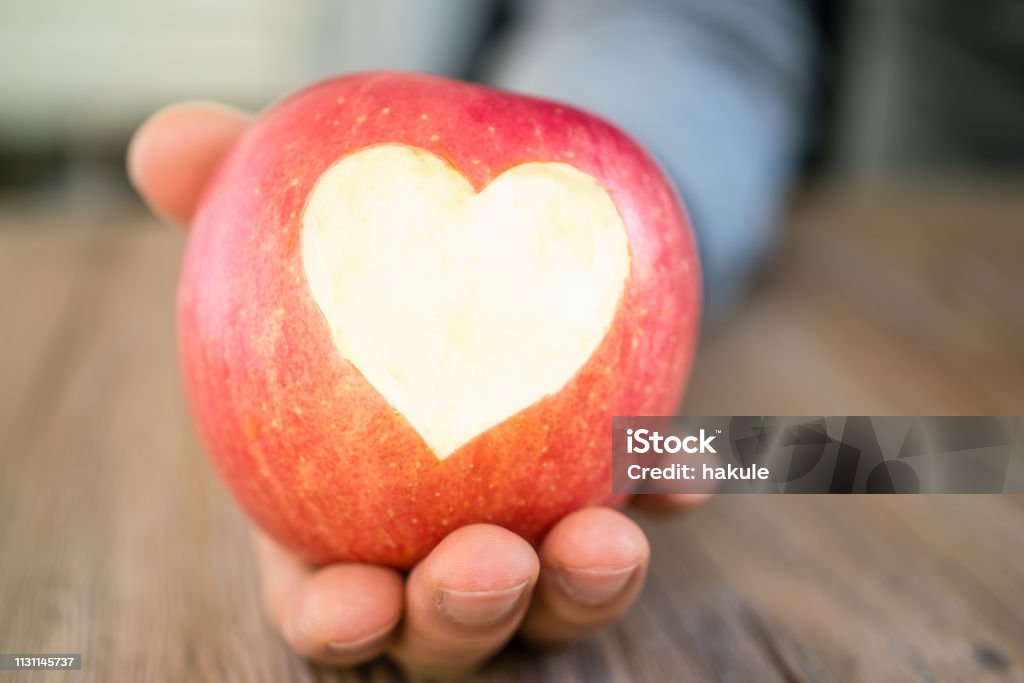 hand holding apple pie with heart shape, concept of love Adult Stock Photo