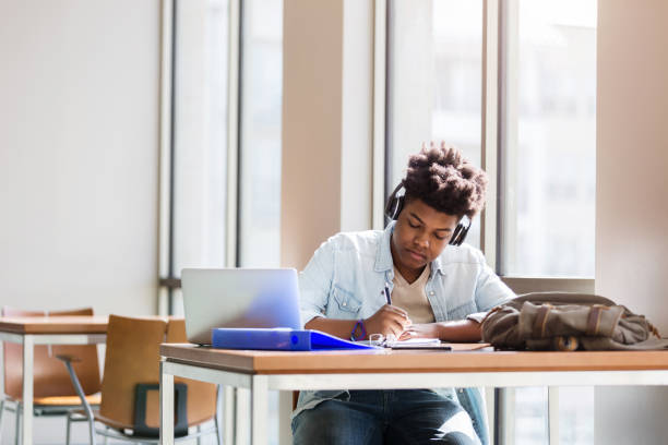 istock Teenage boy studies in school library 1131145984