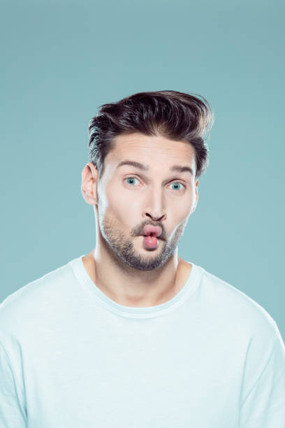 Young man with fish lips Close up portrait of young caucasian man with fish lips against gray background fish lips stock pictures, royalty-free photos & images