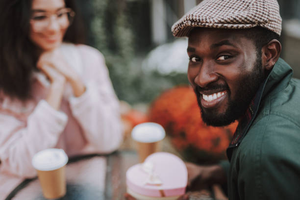istock Young smiling man sitting in cafe on date 1131147148