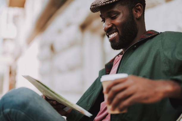 istock Smiling male tourist with map and coffee on bench 1131147174