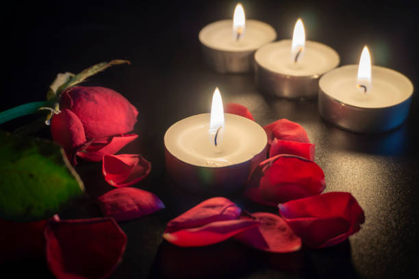 istock Four tea candles and rose petals in the dark 1131147187