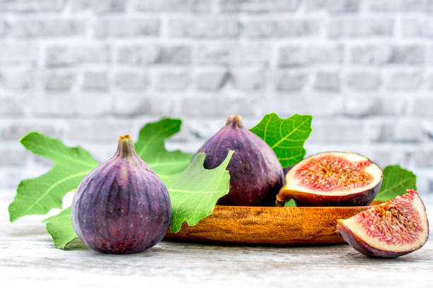 fig fruit on a wooden table with a brick background