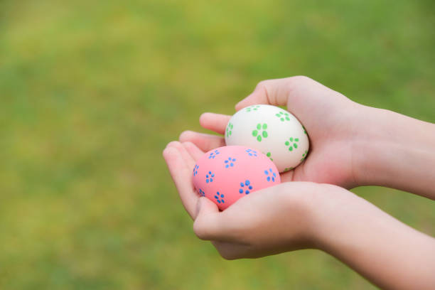 istock Happy Easter Day. Easter eggs concept. Colorful easter eggs in children hands after egg hunting on green grass background. 1131148959