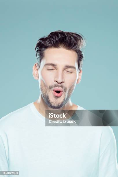Young Caucasian Man Looking Happy Stock Photo - Download Image Now - Eyes Closed, Men, Laughing
