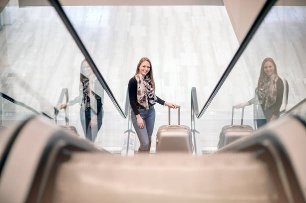 istock Young woman with baggage on escalator 1131151742