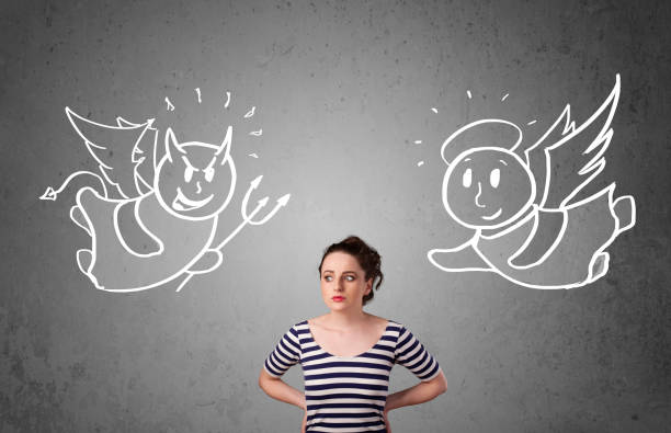 istock Woman standing between the angel and the devil 1131152616