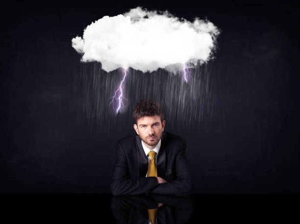 istock Depressed businessman sitting under a cloud 1131152813